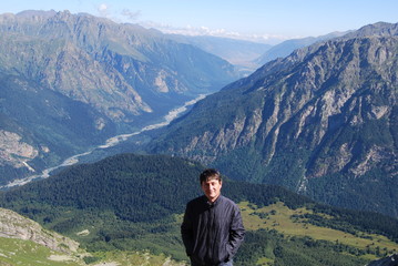 мужчина стоит на фоне гор