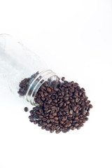 Fototapeta na wymiar Coffee beans pouring out of mason jar