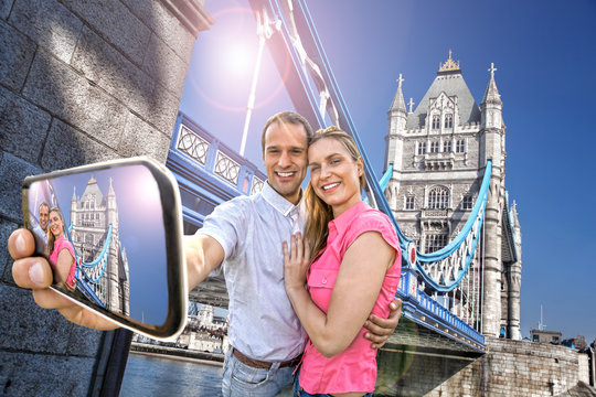 couple taking selfie against Tower Bridge in London, England
