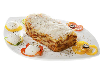 Lasagna Bolognese on a plate with garnish. Isolated on white.
