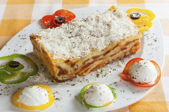 Lasagna Bolognese on a plate with garnish.