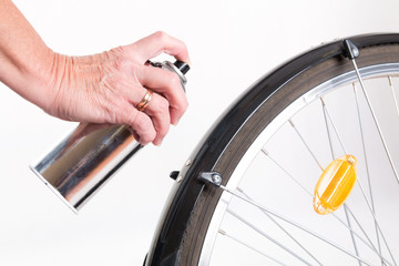 Woman paints the bike fender with spray
