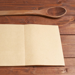 Wooden spoon next to recipe book