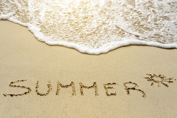 summer word written on the sand beach