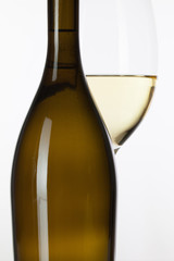 Glass of white wine and brown bottle
