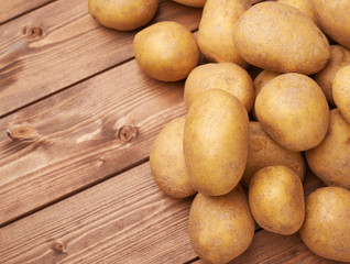 Pile of potatoes over the wooden surface