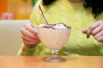 Woman eating chocolate ice cream in cafe