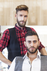 young hipster couple posing in their vintage barber shop