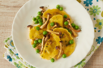 Tortellini with mushrooms and peas on a table