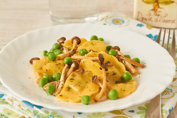 Tortellini with mushrooms and peas on a table