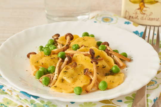 Tortellini with mushrooms and peas on a table