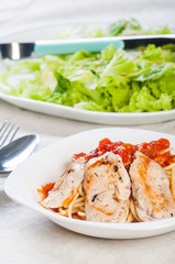 pan fried chicken breast on rich tomato pasta