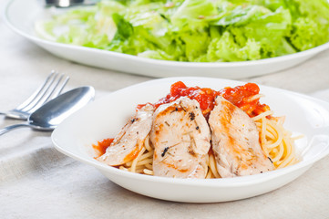 pan fried chicken breast on rich tomato pasta