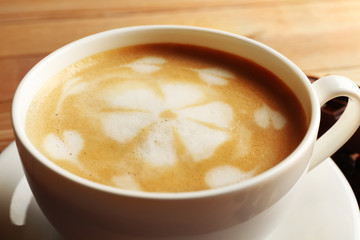 Cup of coffee latte art on wooden table, closeup