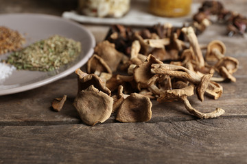 Dried mushrooms with spices on wooden table, closeup