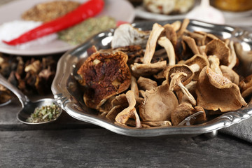 Dried mushrooms with spices on wooden background