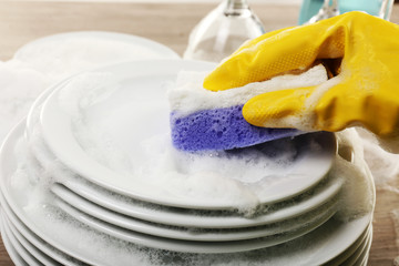 Female hand washing dish close up