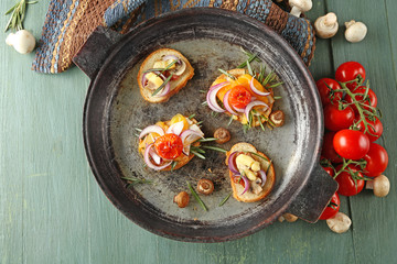 Tasty sandwiches on old pan, on wooden table