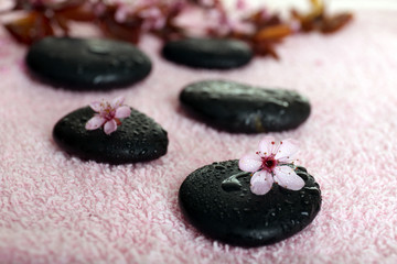 Spa stones and spring flowers on towel background