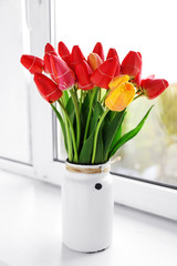 Bouquet of fresh tulips on windowsill background