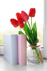 Still life with bouquet of fresh tulips on windowsill background