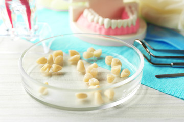 White teeth and dental instruments on table background