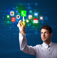 Handsome businessman pressing colorful mobile app icons with bok