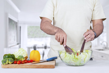 Fototapeta na wymiar Man making organic salad