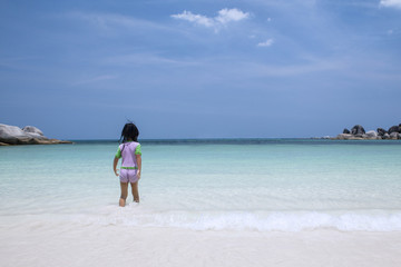 Fototapeta na wymiar Little girl walking alone at beach