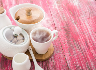 Tea cups with teapot on old wooden table