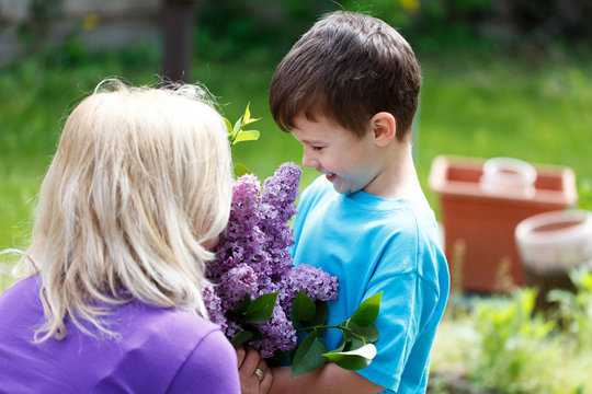 Little boy give lilac to mom mother's day