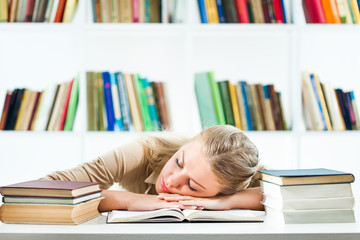 Young woman learning in library, she is too tired