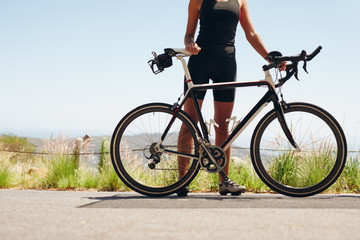 Female athlete standing with her bicycle