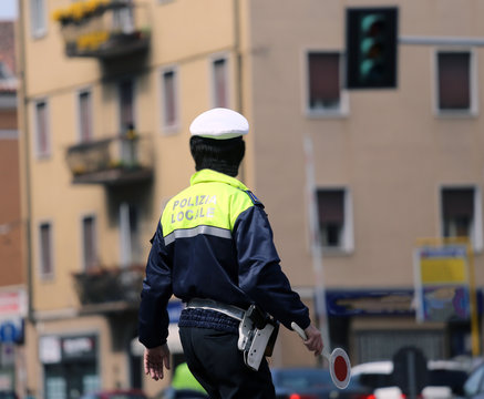 Italian policeman in uniform while blocking traffic with the Red
