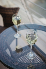 Two glasses of wine standing on balcony with a view at the ocean