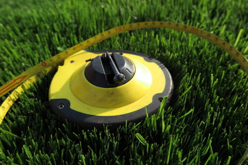 Measuring tape lying on the fresh mown lawn grass