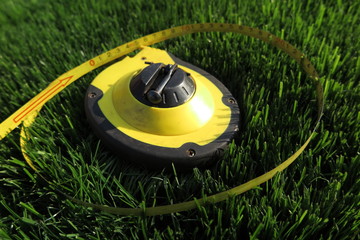 Measuring tape lying on the fresh mown lawn grass