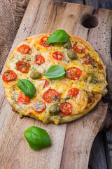 Homemade pizza with cheese and tomatoes on wooden table