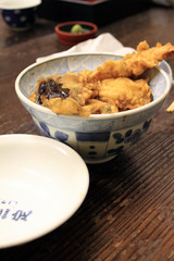 Sushi rice bowl filled with raw seafood..