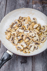 Butter fried sliced mushrooms in a pan.