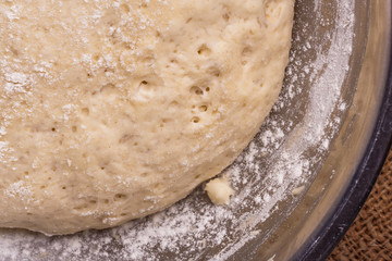 Sourdough yeast dough rises in a bowl on the table