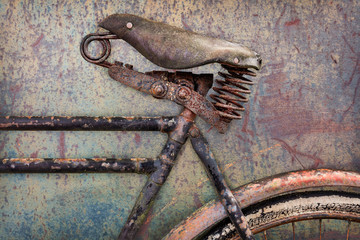 Detail of a rusted ancient bicycle with leather seat