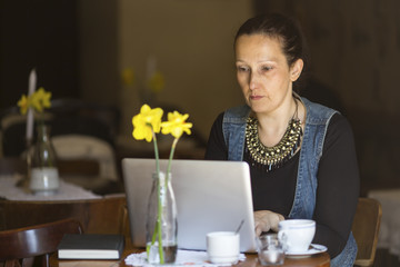 Young woman working with laptop in cafe.