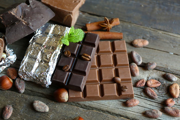 Delicious chocolate with spices on wooden table, closeup