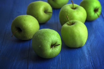 Green apples on color wooden background