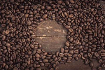 Roasted coffee beans on a rustic old wooden table