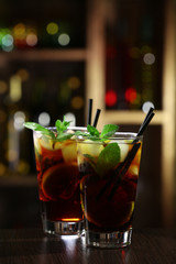 Glass of cocktail in bar on bright blurred background