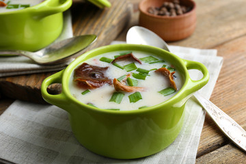 Mushroom soup on wooden table with napkin, closeup