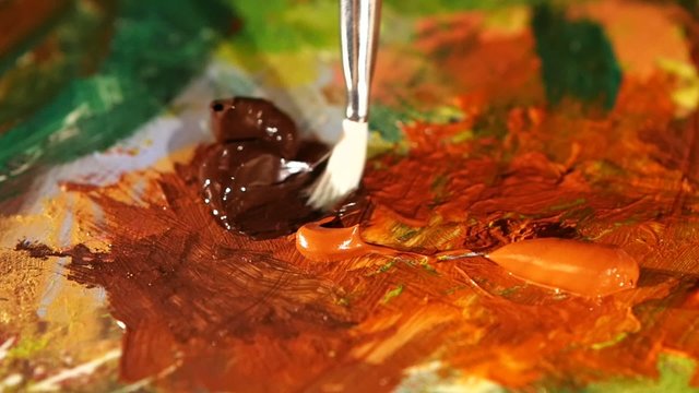 Painter mix brown and orange colors oil painting on palette