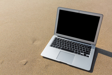 Laptop on the beach in summer time